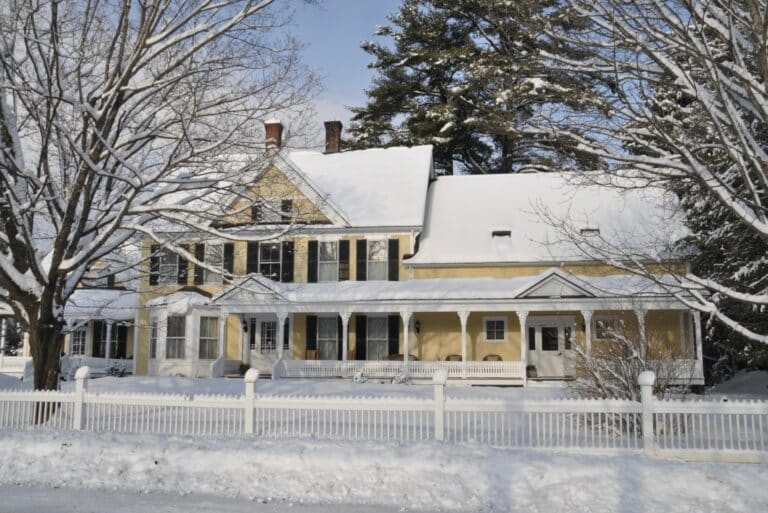 An exterior view of Jackson House Inn, one of the best places to stay in Woodstock, VT, all covered in snow.