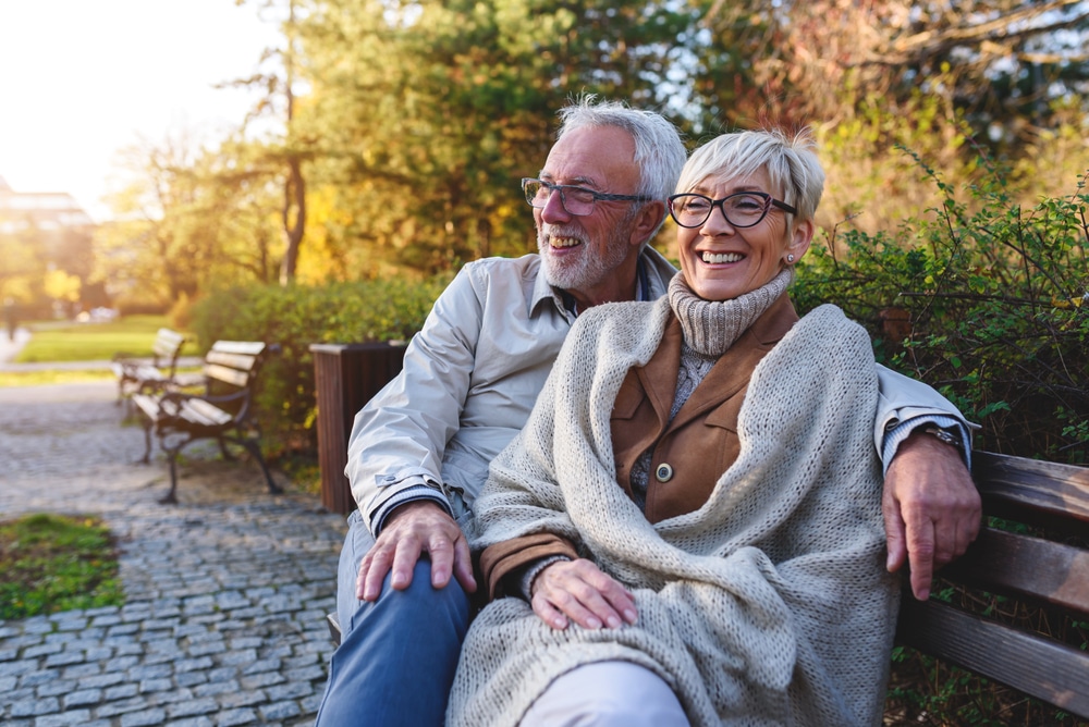 A senior couple sitting on a bench enjoying a Vemront Couples getaway while staying at one of the best Woodstock Vermont hotels